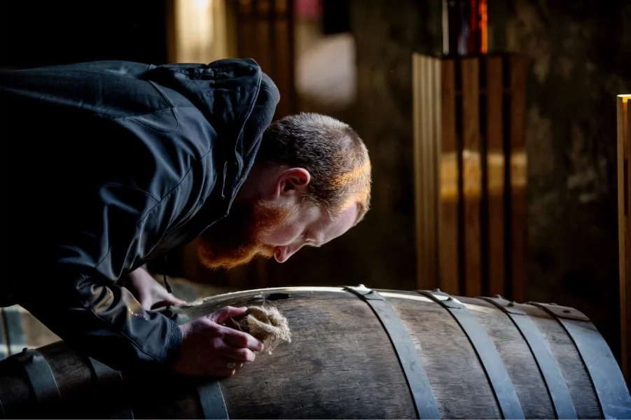 Man inspecting a whisky cask